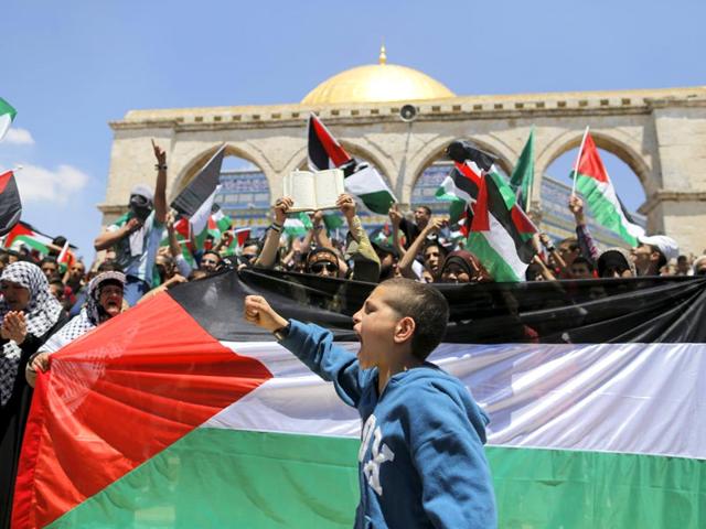 A Palestinian boy shouts slogans as others wave flags after Friday prayers during a protest to mark Nakba day on May 15, 2015 near the Dome of the Rock on the compound known to Muslims as Noble Sanctuary and to Jews as Temple Mount, in Jerusalem's Old City. (Reuters)