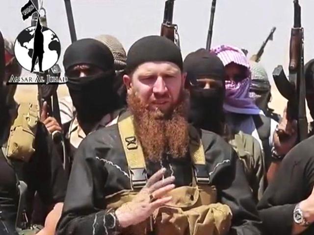 This-image-made-from-an-undated-video-posted-during-the-weekend-of-June-28-2014-on-a-social-media-account-frequently-used-for-communications-by-the-Islamic-State-shows-Omar-al-Shishani-standing-next-to-the-group-s-spokesperson-among-a-group-of-fighters-as-they-declare-the-elimination-of-the-border-between-Iraq-and-Syria-Militant-social-media-account-via-AP This-image-made-from-an-undated-video-posted-during-the-weekend-of-June-28-2014-on-a-social-media-account-frequently-used-for-communications-by-the-Islamic-State-shows-Omar-al-Shishani-standing-next-to-the-group-s-spokesperson-among-a-group-of-fighters-as-they-declare-the-elimination-of-the-border-between-Iraq-and-Syria-Militant-social-media-account-via-AP