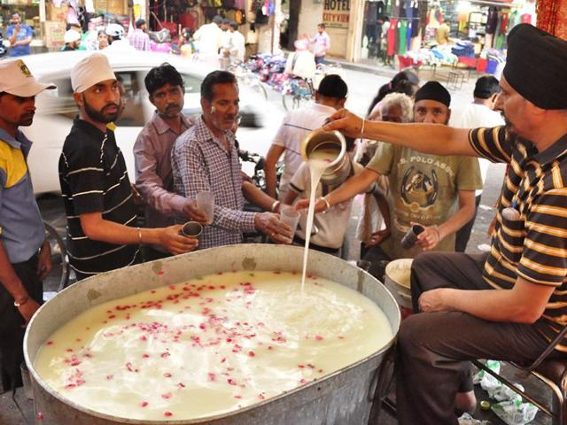 Volunteers offering 'sweet water' to commuters in Ludhiana on Thursday. Sikander Singh Chopra/HT