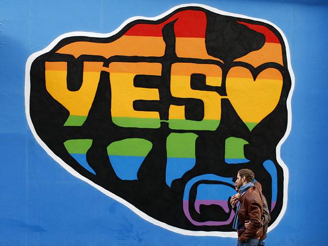 Men-walk-past-a-Yes-vote-campaign-graffiti-in-central-Dublin-as-Ireland-holds-a-referendum-on-gay-marriage-May-22-2015-REUTERS