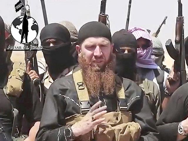 This-image-made-from-an-undated-video-on-a-social-media-account-frequently-used-for-communications-by-the-Islamic-State-shows-Omar-al-Shishani-standing-next-to-the-group-s-spokesperson-among-a-group-of-fighters-as-they-declare-the-elimination-of-the-border-between-Iraq-and-Syria-Militant-social-media-account-via-AP