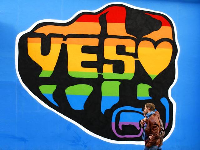 Men walk past a Yes vote campaign graffiti in central Dublin. (Reuters Photo)