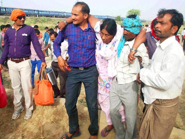 People help a woman injured in the train accident to safety. (PTI Photo)