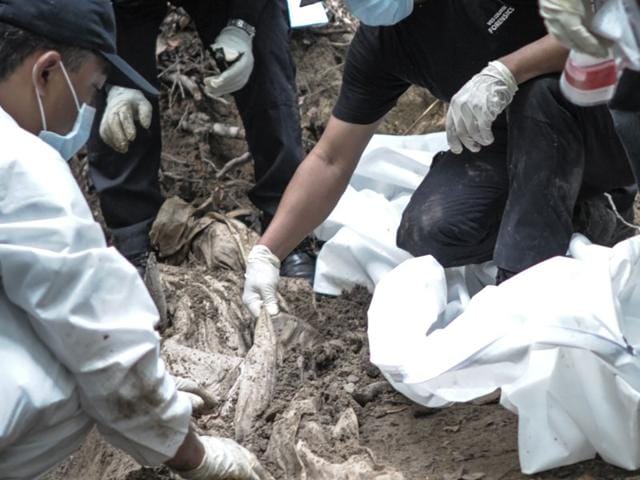 A-Royal-Malaysian-Police-forensics-team-handles-exhumed-human-remains-at-a-grave-site-used-by-people-smugglers-in-a-jungle-at-Bukit-Wang-Burma-in-the-Malaysian-northern-state-of-Perlis-AFP-Photo