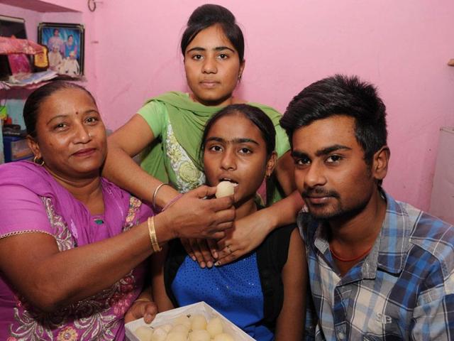 Simran who scored 97.54% with her family members in Kartarpur near Jalandhar. Pardeep Pandit/HT
