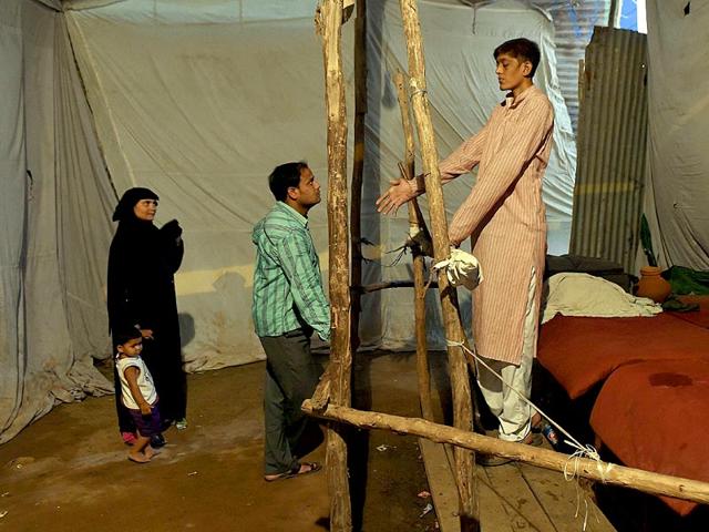 Dharmendra Singh speaks with a visitor as a woman and child look on in an enclosure at the fair (AFP Photo)