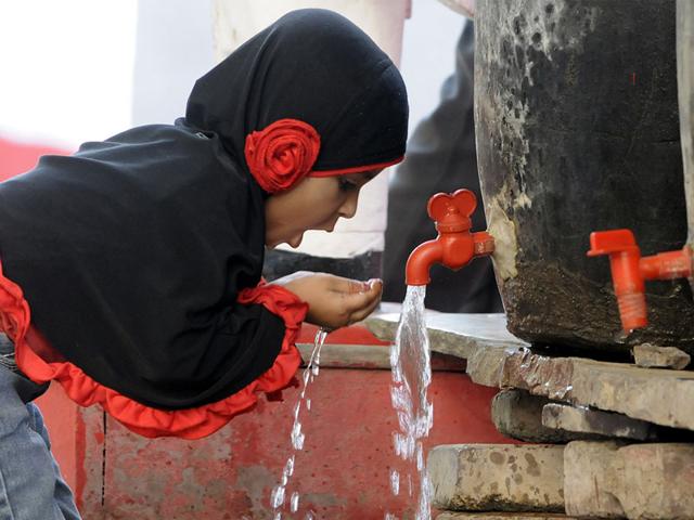 A small girl quenches her thirst in Indore on Wednesday as hot winds till late in the evening kept the city on boil. (Arun Mondhe/HT photo)
