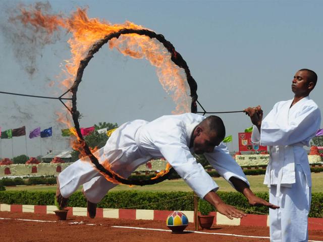 A Sashastra Seema Bal jawan passes through a ring of fire during passing out parade at their training centre in Bhopal on Thursday. (Mujeeb Faruqui/HT photo)