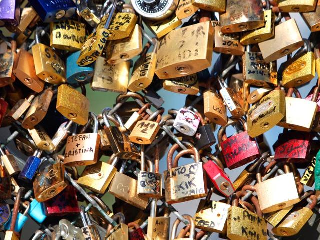 A-couple-locks-a-padlock-on-the-Pont-des-Arts-on-May-29-2015-in-Paris-as-the-Paris-municipalty-announced-that-the-bridge-s-fences-have-to-be-removed-due-to-the-overload-AFP-Photo-Charly-Triballeau A-couple-locks-a-padlock-on-the-Pont-des-Arts-on-May-29-2015-in-Paris-as-the-Paris-municipalty-announced-that-the-bridge-s-fences-have-to-be-removed-due-to-the-overload-AFP-Photo-Charly-Triballeau