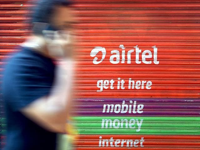 A-pedestrian-talks-on-his-cellphone-while-walking-past-an-advertisement-for-a-telecom-service-provider-in-Mumbai-AFP-Photo