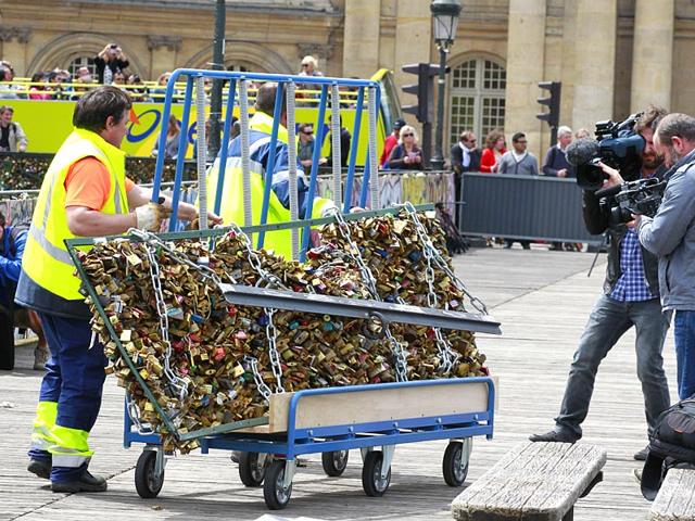 A Paris city employee removes a railing loaded with locks on the famed Pont des Arts bridge in Paris. (AP Photo)