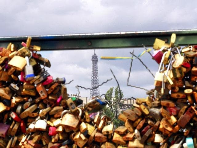 The Eiffel tower appears through the partly lock-free railing of the Pont des Arts bridge in Paris. (AP Photo)