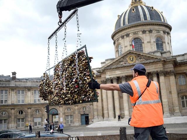 A worker removes 'love padlocks' attached on the railings of the Pont des Arts bridge in Paris. Authorities are looking to recycle the metal used for the padlocks for humanitarian projects 'so that the symbol of love which these couples have invested in them will not be lost entirely'. (AFP Photo)