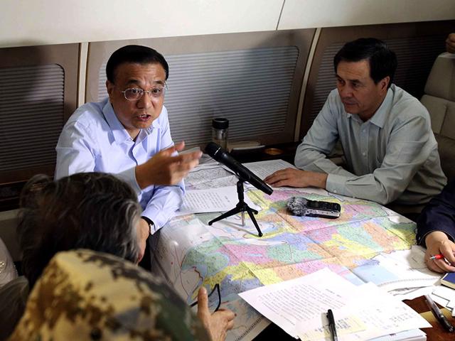In this photo released by China's Xinhua News Agency, Chinese Premier Li Keqiang, center, chairs a meeting to direct search and rescue work as he takes a plane to the site. (AP photo)