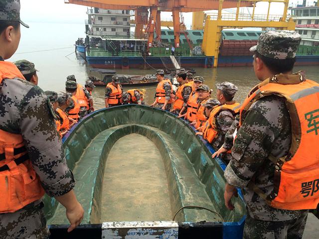 Rescue workers carry a boat as they conduct a search, after a ship sank in the Jianli section of the Yangtze River, Hubei province, China, June 2, 2015.(Reuters photo)