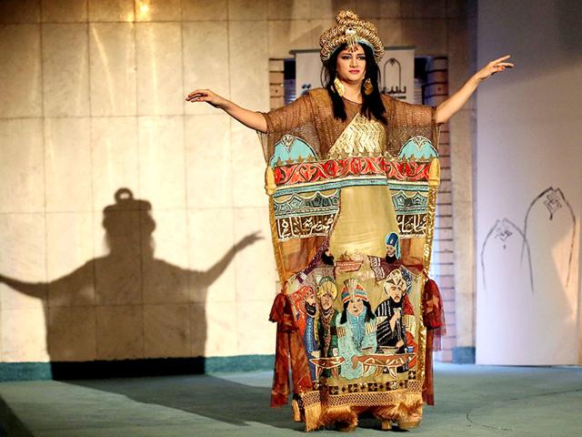 A model wearing a traditional Iraqi costume dances during the opening day of a fashion show at Baghdad's Fashion Institute on June 1, 2015. (AP)