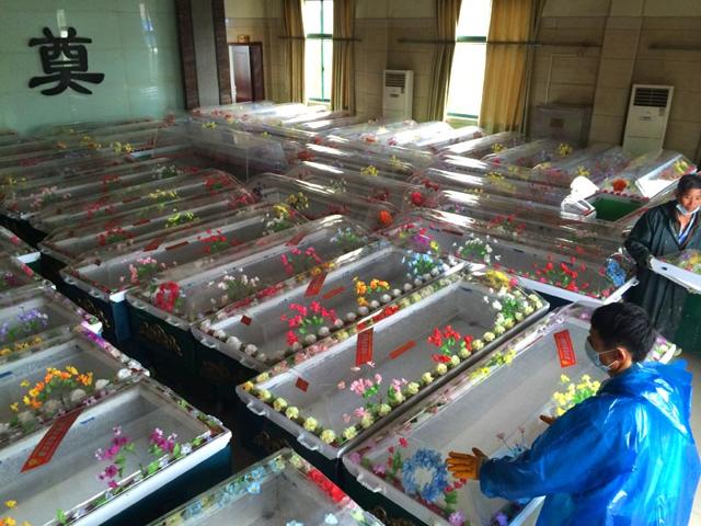 Staff in Jianli funeral parlor prepare ice coffins for victims who were travelling on the capsized passenger ship Dongfangzhixing or "Eastern Star" in the Yangtze river (AFP Photo)