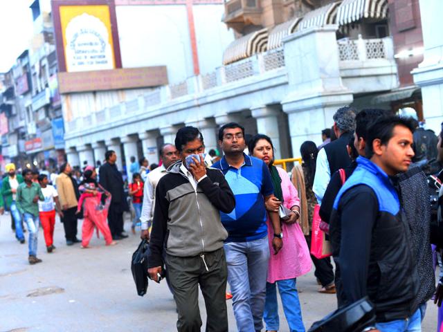 A pedestrian covers his face with a handerchief as he walks along a busy street in New Delhi. AFP Photo