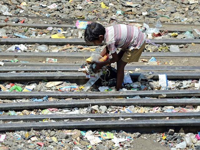 A child rummages through garbage in an open space adjoining a slum in Mumbai. AFP Photo