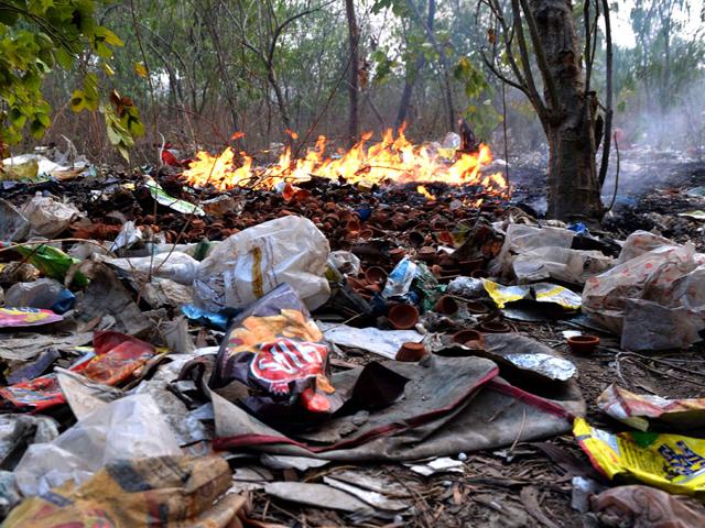 Polythene bags on fire along with other waste material at a garbage dump in Sahibabad in Ghaziabad. AFP Photo