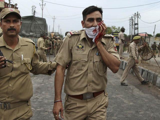 An injured police officer during a protest in Jammu after the police removed posters of Sikh leader Jarnail Singh Bindranwale. Photo courtesy: AP