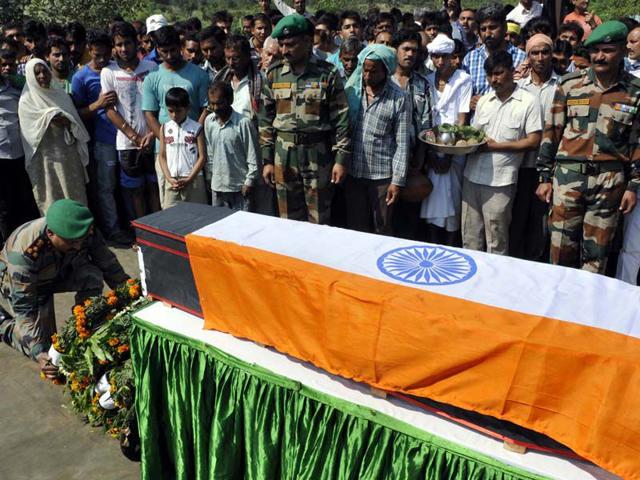 Army officer paying tribute to LNK Kuldeep Raj, who was killed in ambush in Manipur, at Ambh Gharota village in the outskirts of Jammu on Sunday. Nitin Kanotra/HT