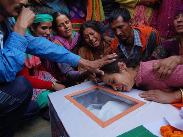 Family members of martyr Vikas bhardwaj wail near his body during his funeral at his native village Patoon Pandol Ladbhrol in district Mandi on Sunday. Birbal Sharma/HT
