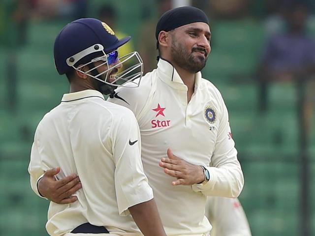 Harbhajan Singh celebrates with teammate Ajinkya Rahane after dismissing a Bangladesh batsman during the one-off Test match between Bangladesh and India at Fatullah on June 13, 2015. (AFP Photo)