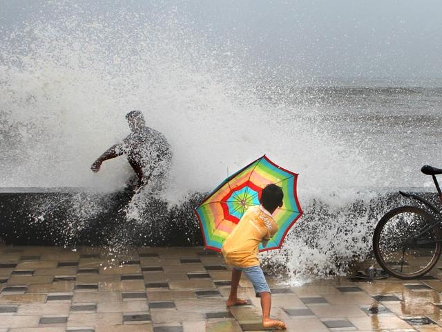 A child shields himself from the high tide at Worli sea face, in Mumbai. The city witnessed heavy rainfall. (Arijit Sen/HT photo)