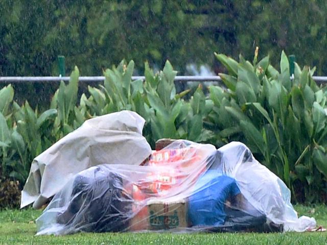 People cover themselves with a polythene during a storm accompanied by shower in New Delhi (PTI Photo)