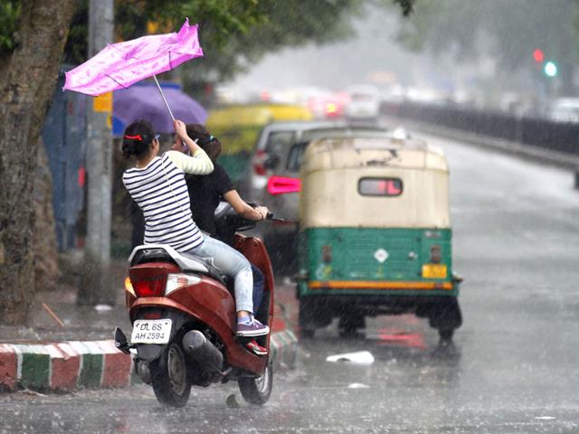 Girls escaping the rain near Connaught Place during the late afternoon shower. (Virendra Singh Gosain/ HT Photo)