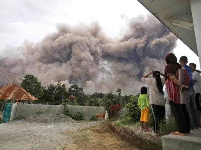 Villagers watch as Mount Sinabung releases pyroclastic flows in Tiga Serangkai, Indonesia. (AP Photo)