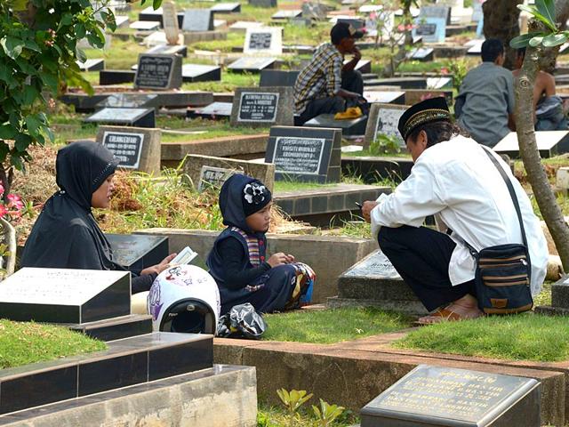 Indonesian people offer prayers at a cemetery ahead of the holy Muslim month of Ramadan in Jakarta (AFP Photo)