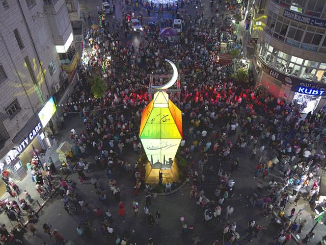 Palestinians watch the lighting of a big lantern to mark the upcoming Islamic holiday of Ramadan at the center of the West Bank city of Ramallah (AP Photo)