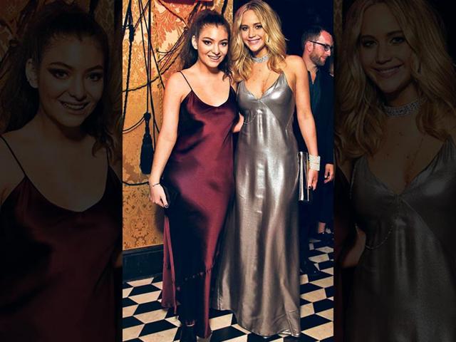 Takes two to rock: Singer Lorde (left) and actor Jennifer Lawrence go style twinning in matching silk slip dresses. While Lorde kept the rocker vibe in cat-eye makeup and messy ponytail, Lawrence went chic with diamond encrusted bling. (AFP Photo)