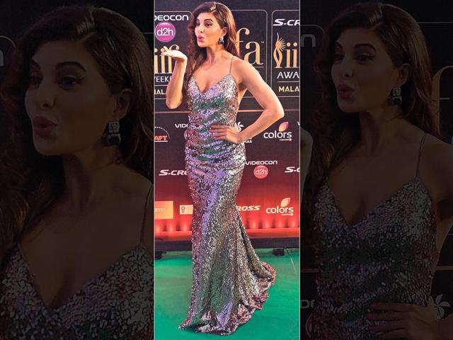 Slip on sparkle: Actor Jacqueline Fernandez makes a floor-grazing strappy, sequinned slip dress pop more with her hot pink lipstick and statement earrings. (AFP Photo)