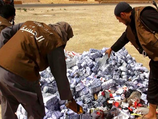 In-this-photo-released-on-May-3-2015-by-a-militant-website-members-of-the-Islamic-State-group-s--vice-police-known-as-Hisba-prepare-to-burn-cigarettes-and-alcohol-in-Homs-Province-Syria-AP-Photo In-this-photo-released-on-May-3-2015-by-a-militant-website-members-of-the-Islamic-State-group-s--vice-police-known-as-Hisba-prepare-to-burn-cigarettes-and-alcohol-in-Homs-Province-Syria-AP-Photo