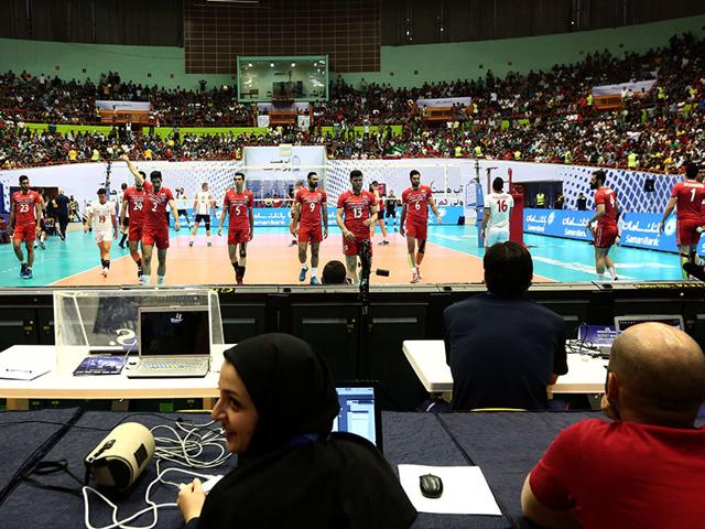 An-Iranian-employee-of-Iran-s-volleyball-federation-smiles-as-Iranian-players-warm-up-before-the-volleyball-match-Iranian-authorities-had-denied-women-ticket-holders-entry-to-the-match-AFP-Photo An-Iranian-employee-of-Iran-s-volleyball-federation-smiles-as-Iranian-players-warm-up-before-the-volleyball-match-Iranian-authorities-had-denied-women-ticket-holders-entry-to-the-match-AFP-Photo