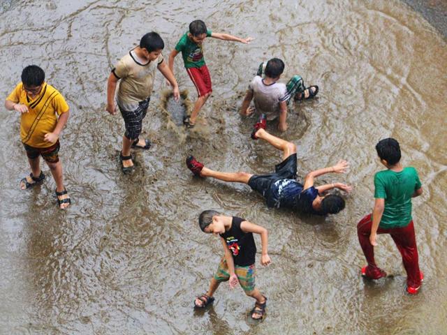 Children play in the rain, in Mumbai. (Photo: Praful Gangurde)