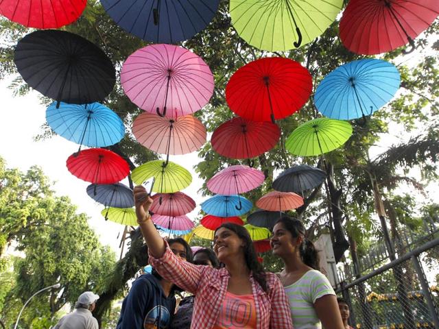 Young visitors take selfies under an umbrella installation at Mumbai's Selfie point. (Kunal Patil/HT photo)