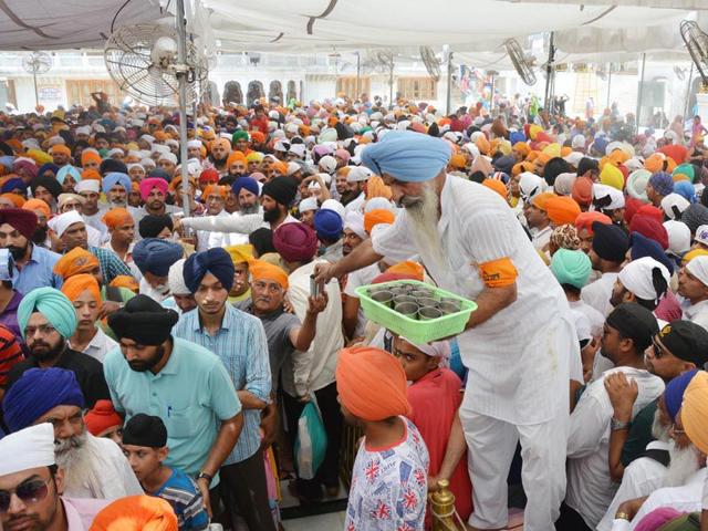 Sevadaar's serving cold water to the people standing in long queue's before entering sanctum sanctorum at Golden temple in Amritsar on Sunday. Sameer Sehgal/HT