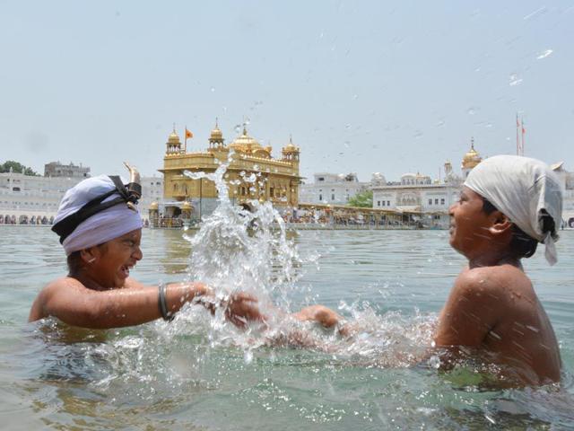 Children enjoying the Holy Dip at the Golden temple while getting relief from the sweltering heat in Amritsar on Sunday. Sameer Sehgal/HT