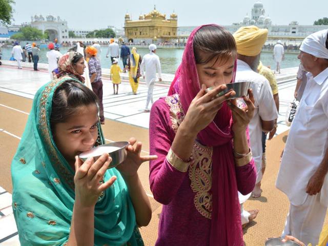 Sweetened water being served to devotees at the Golden Temple complex during hot day in Amritsar on Sunday. Sameer Sehgal/HT