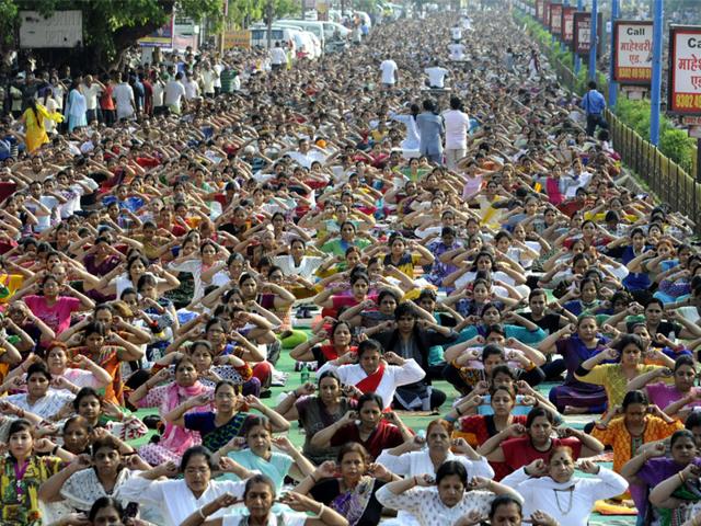 Residents perform yoga on the road along Dussehara Maidan to mark International Day of Yoga in Indore on Sunday. (Shankar Mourya/ HT)