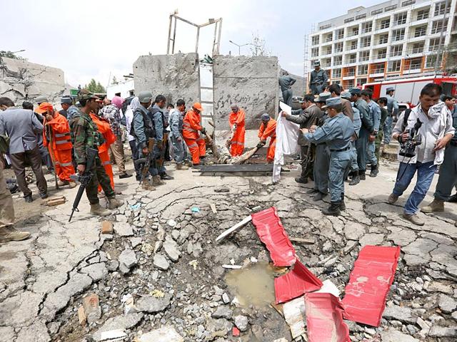 Afghan security forces inspect the site of a suicide attack after clashes with Taliban fighters in front of the Parliament, in Kabul. The Taliban launched a complex attack on the Afghan parliament, with a suicide car bomber striking at the entrance and gunmen battling police as lawmakers were meeting inside to confirm the appointment of a defense minister, police and witnesses said. (AP Photo)