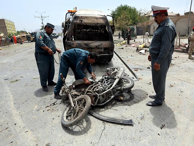 Afghan security forces inspect damages at the site of the suicide attack outside the Parliament building in Kabul. (AP Photo)