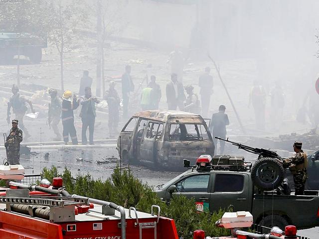 Members of security forces stand at the site of the attack. A Taliban suicide bomber and six gunmen attacked the Afghan Parliament, wounding at least 19 people and sending a plume of black smoke across Kabul. (Reuters Photo)