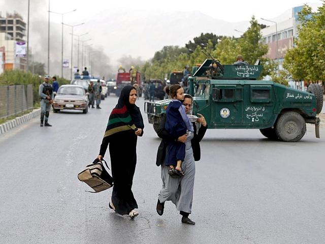 Women walk past as smoke rises from the site of the suicide attack near the Afghan Parliament. (Reuters Photo)