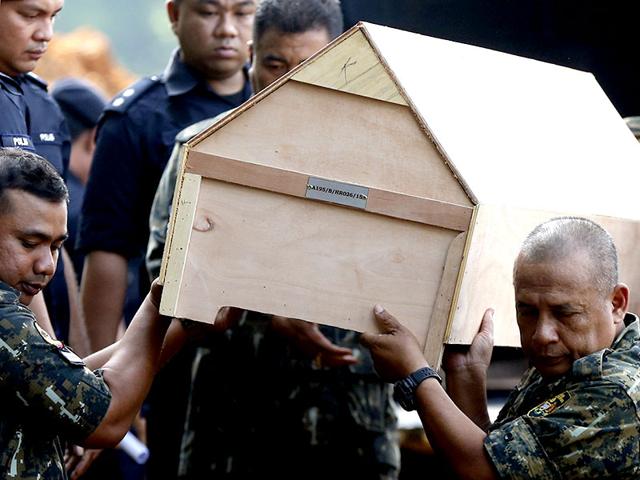 Malaysian police carry a coffin with unidentified remains of Rohingya people found at a traffickers camp in Wang Kelian (Reuters Photo)