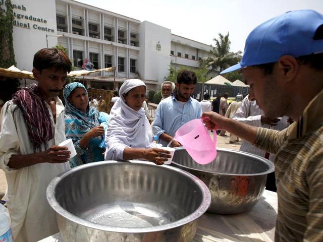 People receive drinking water from a volunteer at a stall, set up outside the Jinnah Postgraduate Medical Centre (JPMC) in Karachi, Pakistan. (Reuters Photo)